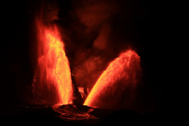 Two lava fountains erupt near to each other, with each tilting off in opposite directions.