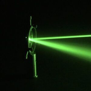 a green laser beam reflected off a piece of optical equipment.