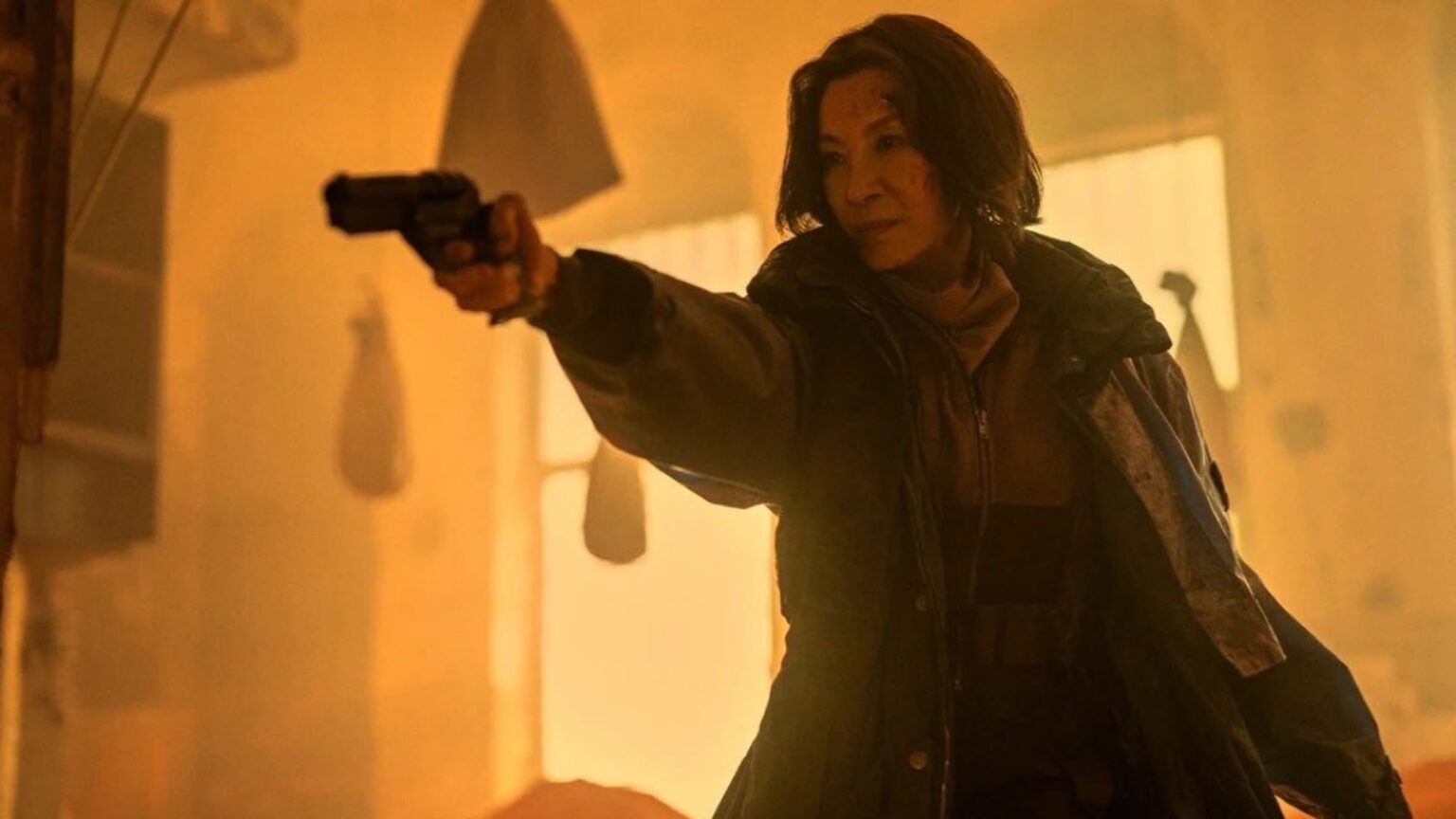 Asian woman in trench coat pointing a gun