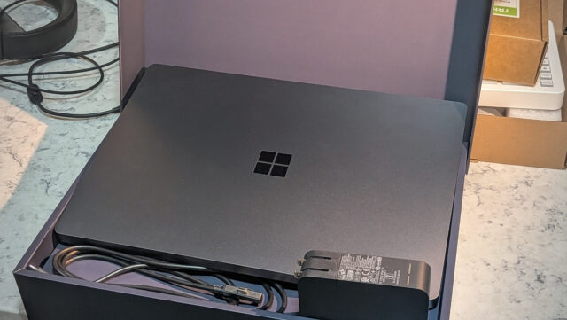 The Surface Laptop Ultra sits in its box with the charger and magnetic cable.