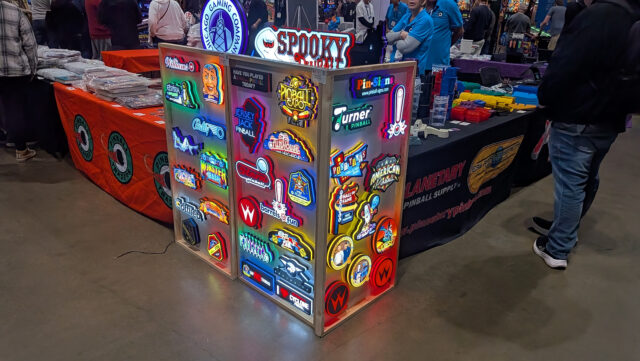 A vendor selling custom lit up pinball logo signs.