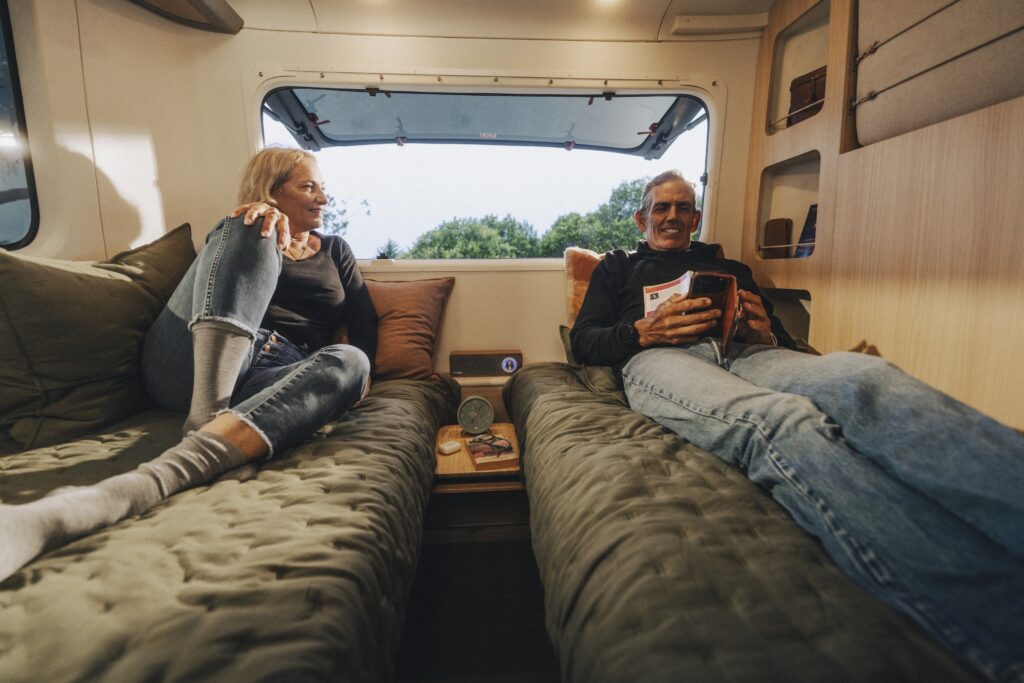 two people relax inside a trailer.