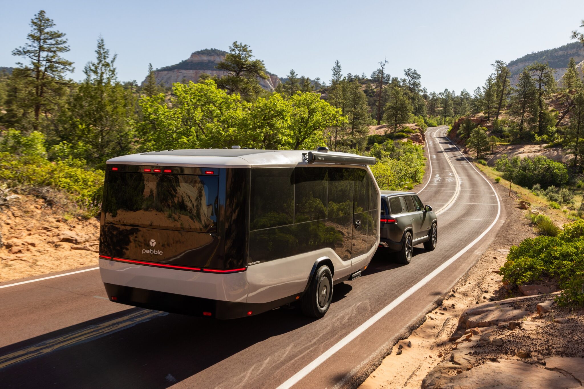 A Pebble Flow trailer being towed by a Rivian.