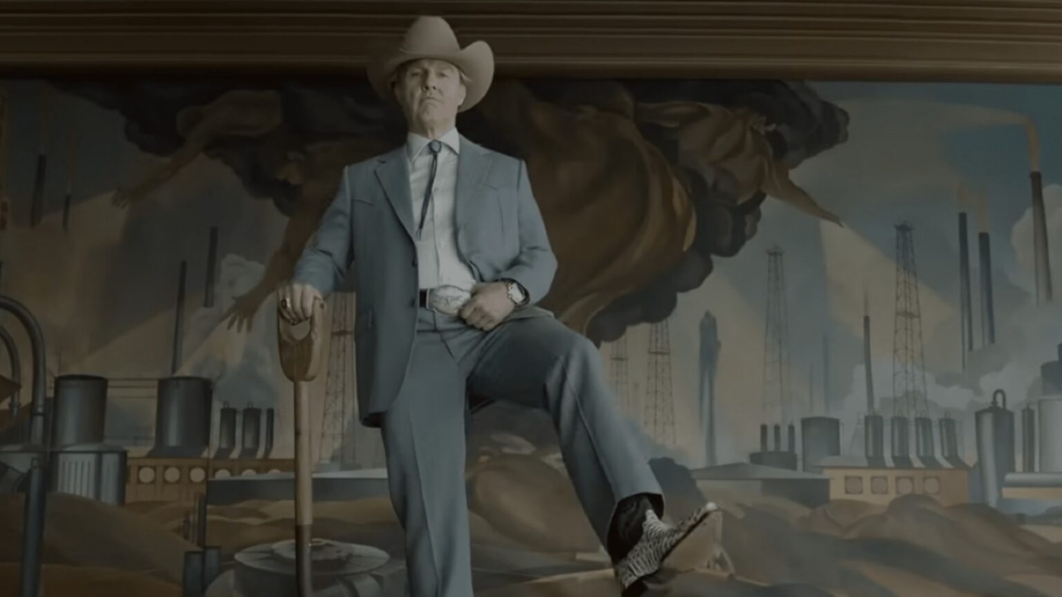 elderly man in a light blue suit and cowboy hat and boots holding a shovel