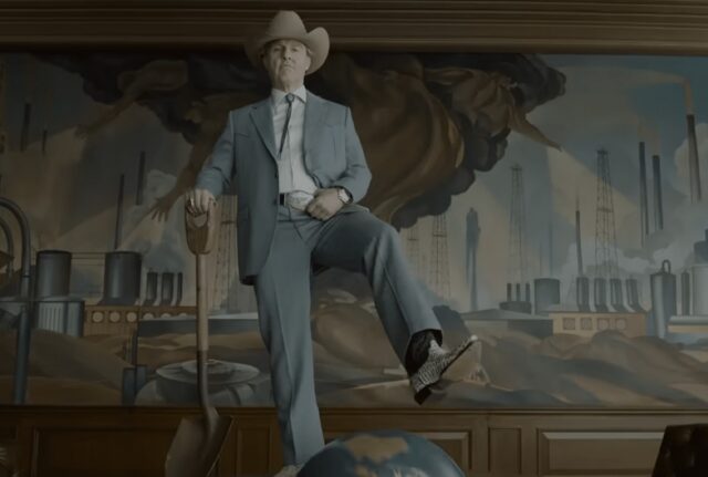 elderly man in a light blue suit and cowboy hat and boots holding a shovel