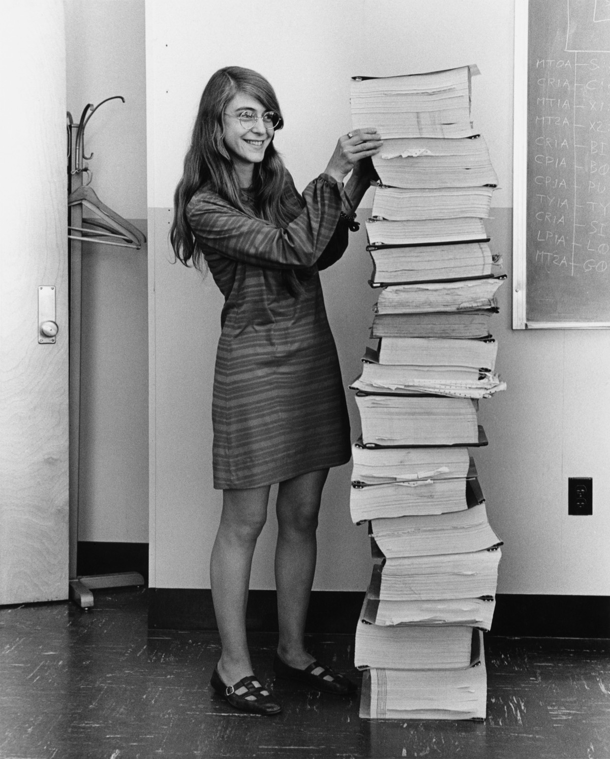 Hamilton in 1969, standing next to listings of the Apollo guidance software she and her MIT team produced. (retouched)