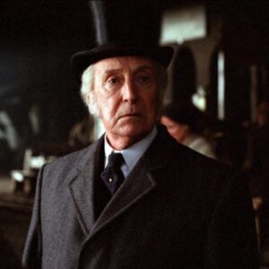 Gray haired man in Victorian suit and top hat
