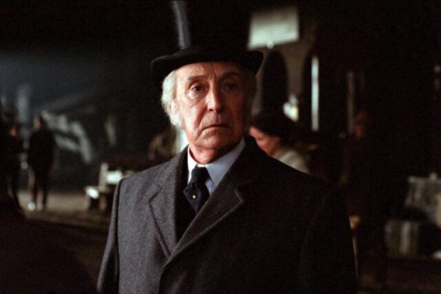 Gray haired man in Victorian suit and top hat