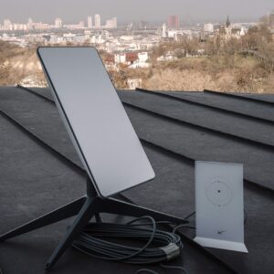 A Starlink terminal and router on a rooftop in Kyiv, Ukraine. City buildings are visible in the background.