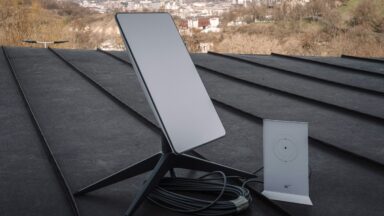 A Starlink terminal and router on a rooftop in Kyiv, Ukraine. City buildings are visible in the background.