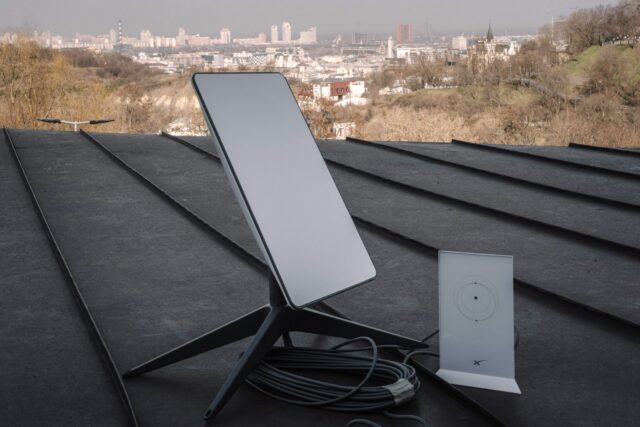 A Starlink terminal and router on a rooftop in Kyiv, Ukraine. City buildings are visible in the background.