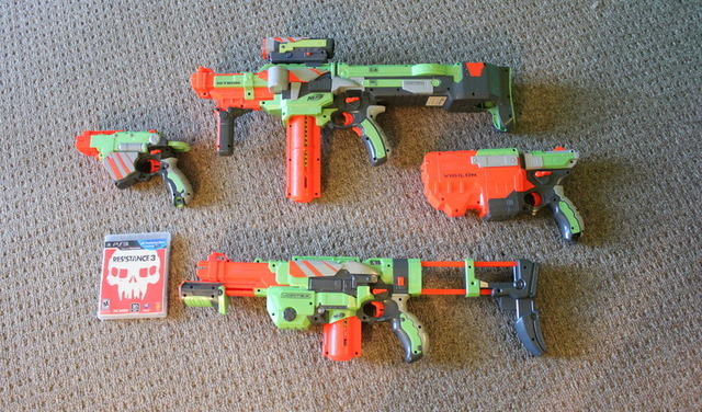 A picture of all four blasters next to a PS3 game for reference. These are some large weapons.