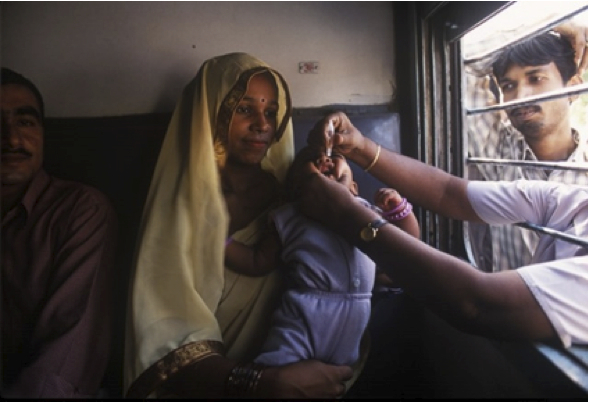 Reaching out to mobile populations: a child is vaccinated through the window of a train.