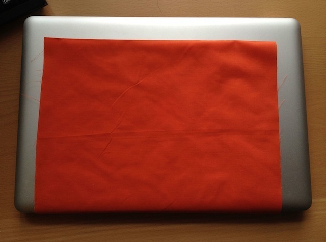 The laptop hammock fabric, cut to size, falling an inch or two short of the edge of the computer on three sides.