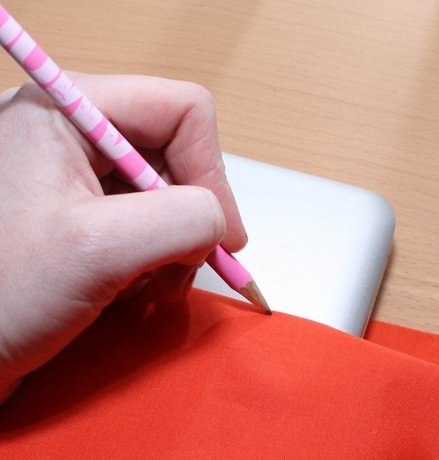 Marking how far the fabric should come up the side of the notebook.