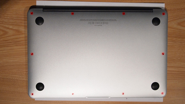 The underbelly of a MacBook Air. The ten screws that hold on the bottom panel are highlighted in red.