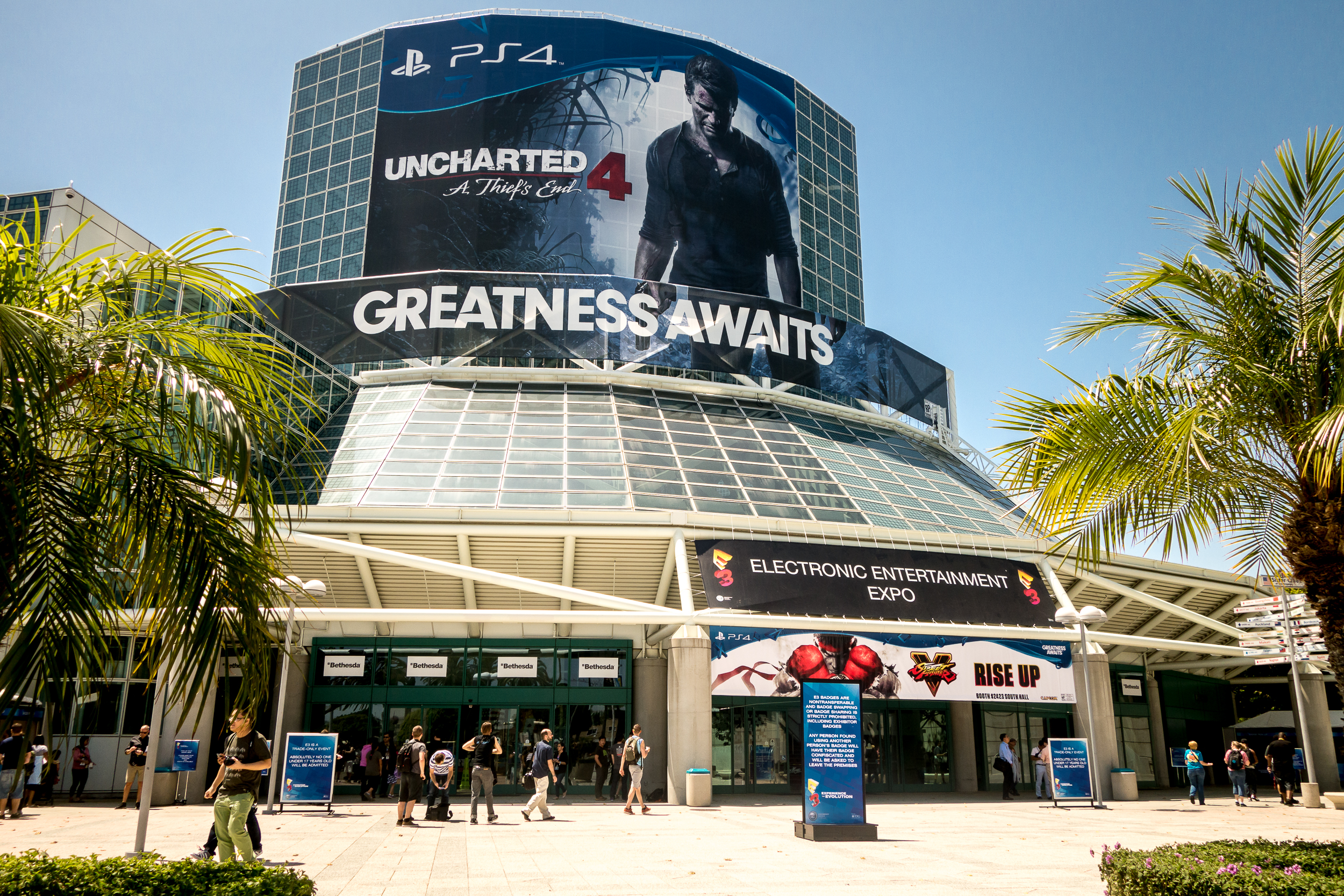 Visitors are reflected in a PlayStation 4 sign outside the Sony